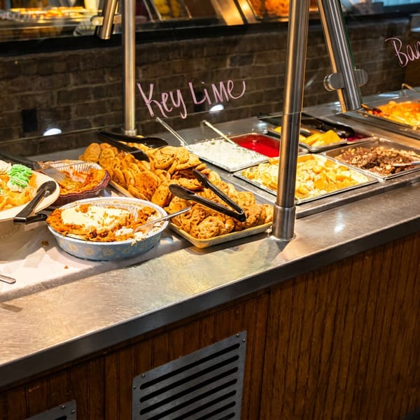 Dessert buffet with pecan pie, key lime pie, cupcakes, cookies, and various puddings.